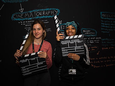 Two students, each holding a Clapperboard